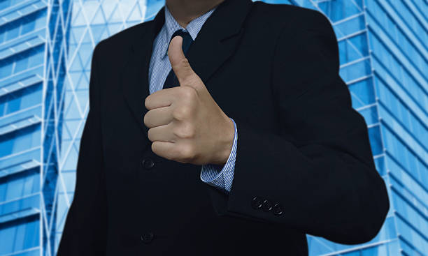 istock Businessman with thumbs up on city tower 494827098
