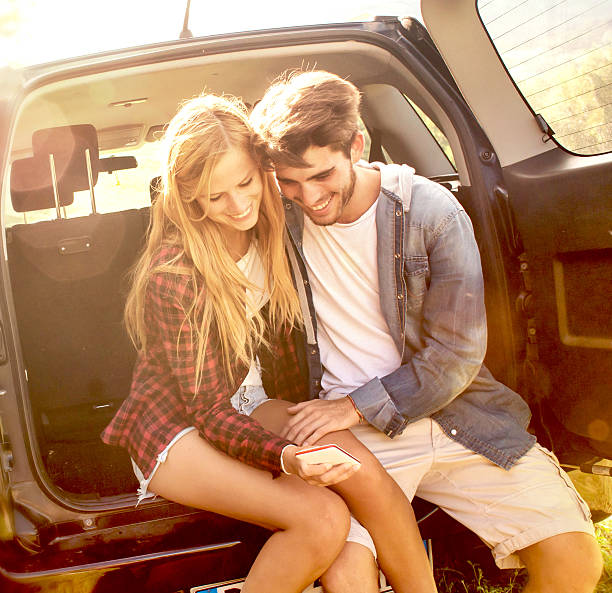 istock Couple Using Mobile Phone in a Car Trunk 494828322