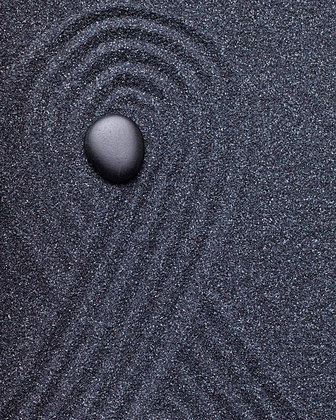 istock Zen garden with a black stone with wave patterns 494829380