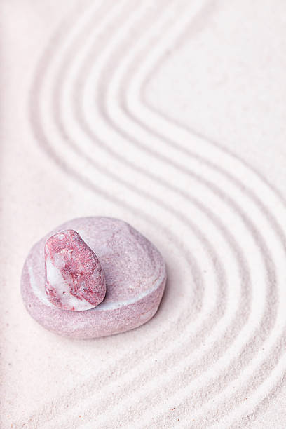 istock Stack of purple quartz and beige stones in the sand 494829718