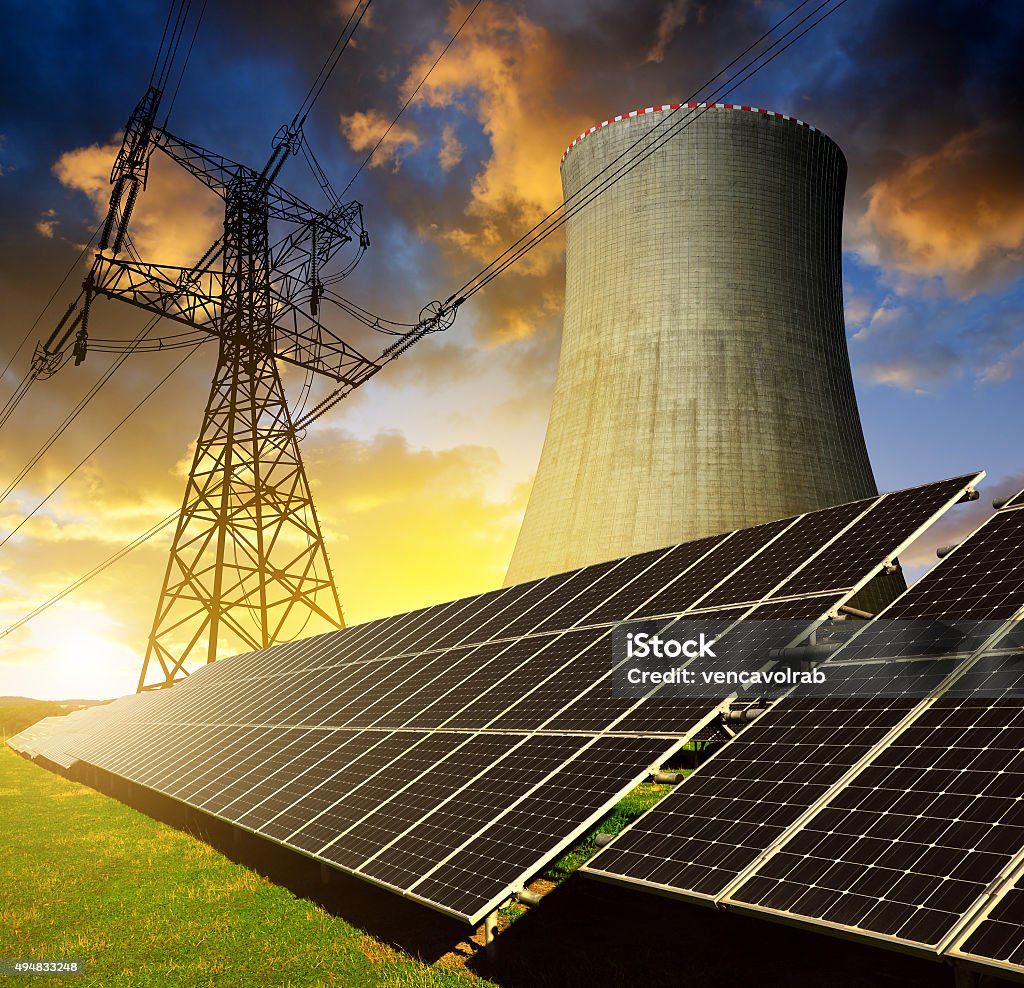 Solar energy panels, nuclear power plant and electricity pylon Solar energy panels, nuclear power plant and electricity pylon at sunset 2015 Stock Photo