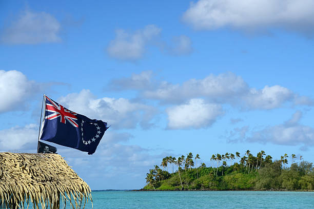 A Cook Island and pirate flag fly from the thatched roof of a boat in Muri Lagoon on Rarotonga.
