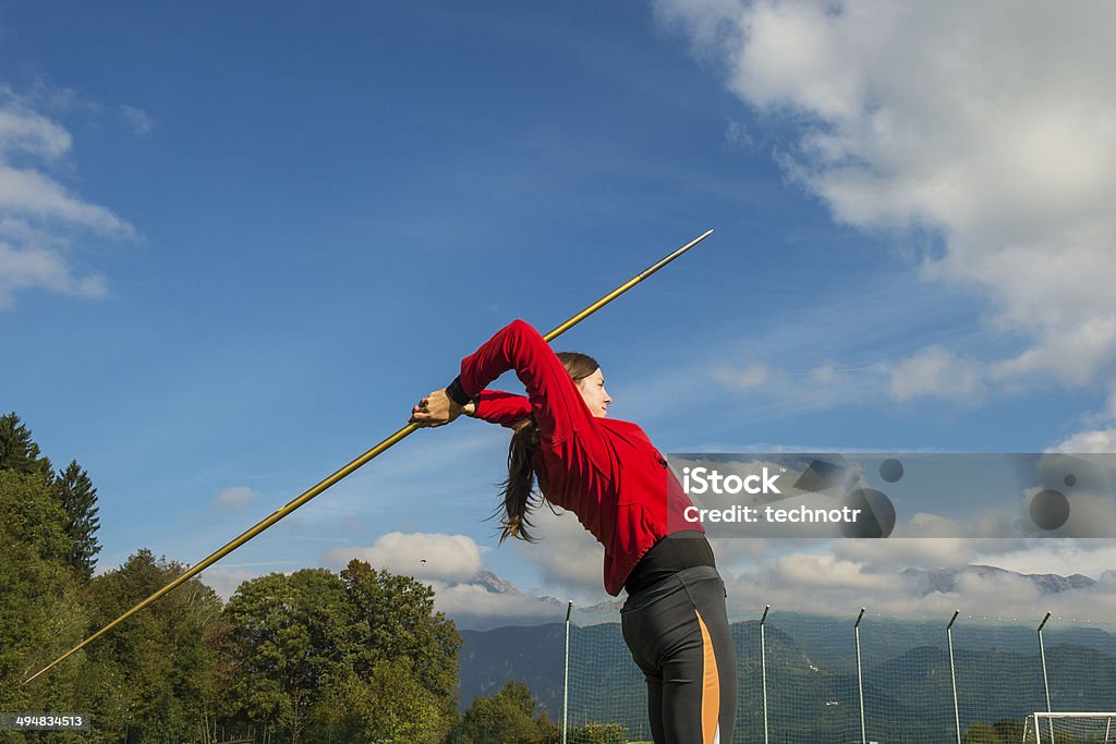 Side View of Young Women  Practicing Javelin Throw Side view of young female athlete throwing the javelin with two hands Accuracy Stock Photo
