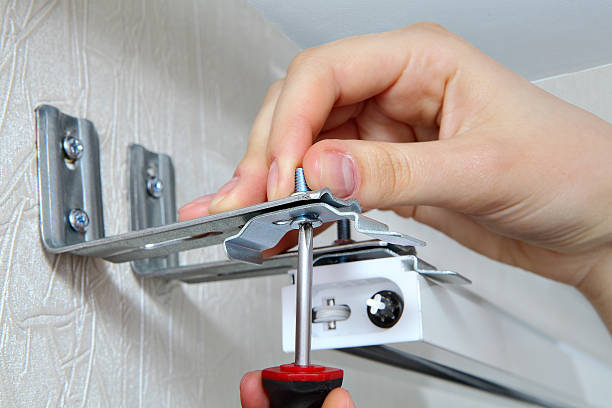 istock vertical blinds mounting brackets, hand with a screw close up 494840799