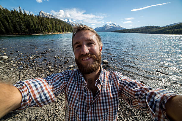 istock Young man by the lake taking a selfie portrait. 494852796