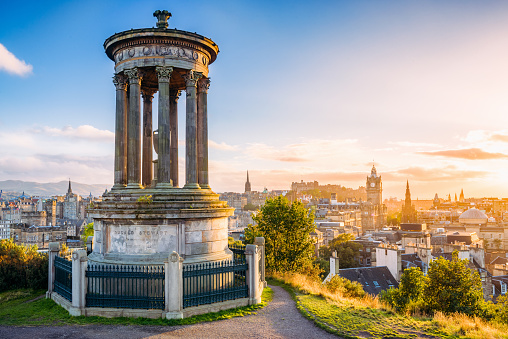 A view over central Edinburgh at sunset, taken from Calton Hill, with the stone memorial to  Dugald Stewart (1753 - 1828) in the foreground.