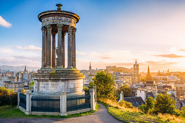 Historic Edinburgh from Calton Hill at sunset A view over central Edinburgh at sunset, taken from Calton Hill, with the stone memorial to  Dugald Stewart (1753 - 1828) in the foreground. edinburgh scotland photos stock pictures, royalty-free photos & images