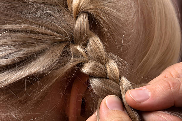 istock hands of hairdresser weaving braid 494855980