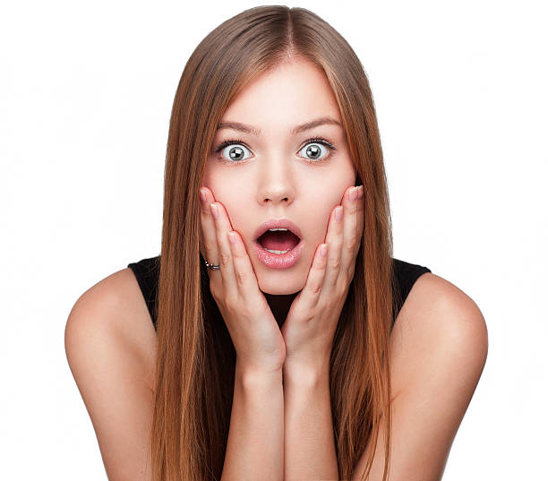 Close-up portrait of surprised beautiful girl Close-up portrait of surprised beautiful girl holding her head in amazement and open-mouthed. Over white background. large eyes stock pictures, royalty-free photos & images