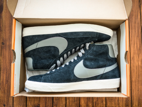 Florence, Italy - May 30, 2014: Close up of the new Nike blazer High vintage ND on a plank wood inside their box package. This shoes are an icon since 70's. Nike is one the most famous American and world footwear company. Image taken indoors on a plank wood.