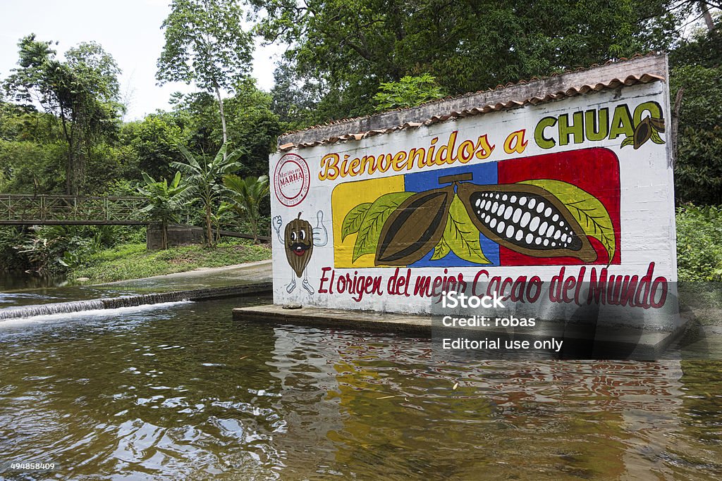 Painted entrance plate at cocoa plantation in Venezuela Chuao, Venezuela - September 20, 2013: Painted welcome sign at the cocoa plantation of the little village of Chuao in Venezuela. The sign is a concrete wall, standing in a shallow river. Cacao Fruit Stock Photo