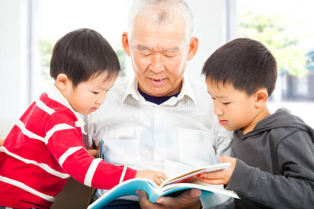 istock grandfather and grandchildren reading a book 494860149