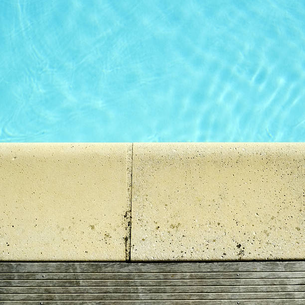 istock Decking and stone edging detail around a swimming pool 494876320