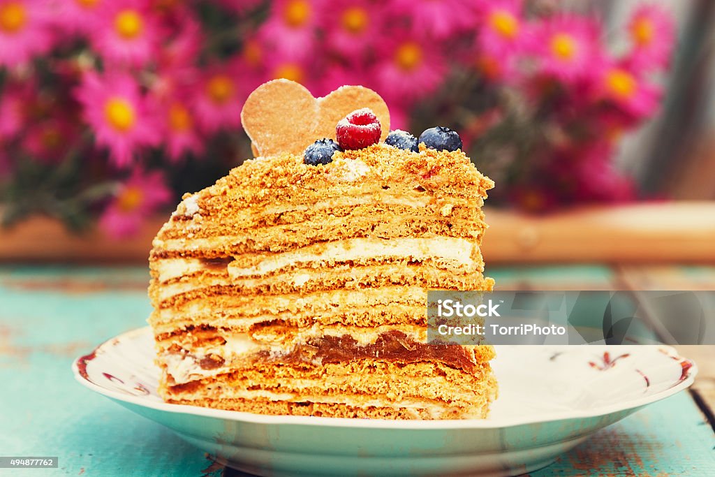 Slice of layered honey cake Slice of layered honey cake on rustic wooden background. Homemade baking 2015 Stock Photo