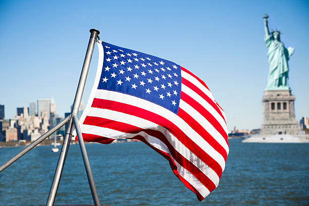 istock Statue of Liberty with American flag in foreground. 494879544