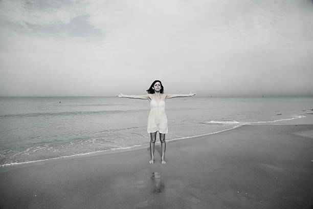 istock beautiful woman standing on the beach 494879622