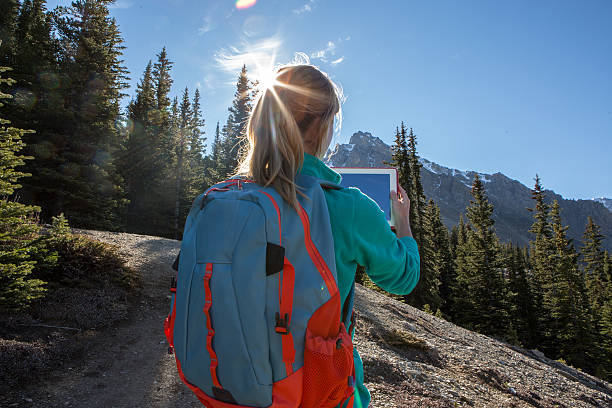 istock Woman hiking photographing landscape using digital tablet 494880072