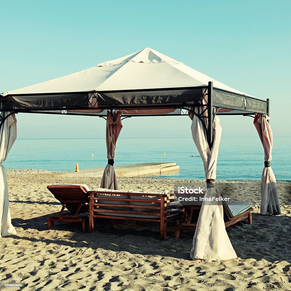gazebo beds on tropical sand summer beach, Greece gazebo beds on tropical sand summer beach, Greece. Square toned image, instagram effect Beach Stock Photo