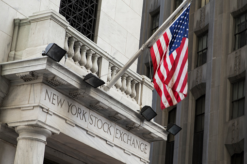 New York, NY, USA - October 22, 2015 The New York Stock Exchange with the American Flag raised out front.  The Stock Exchange is located on Wall Street in the financial district of Manhattan, NY.  
