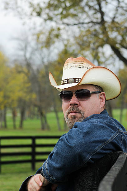 istock Man Looks Left and Poses For Camera While Against Fence 494893212