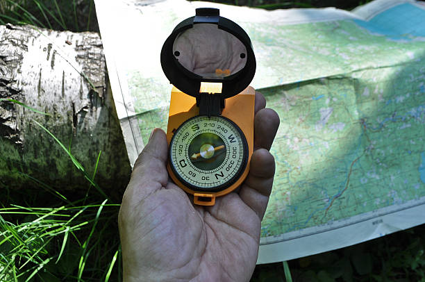 istock Compass in hand, against background of the map. 494894477