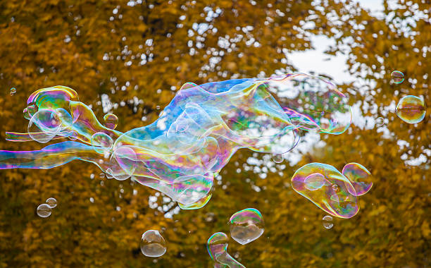 istock soap bubbles flying in the air with trees background 494895242
