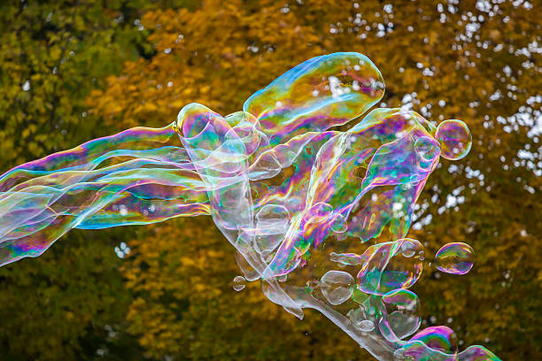 istock soap bubbles flying in the air with trees background 494895490