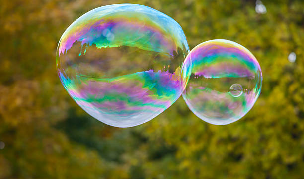 istock soap bubbles flying in the air with trees background 494895572