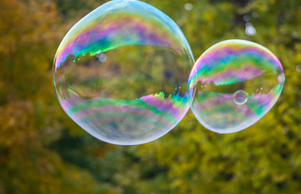 istock soap bubbles flying in the air with trees background 494895594