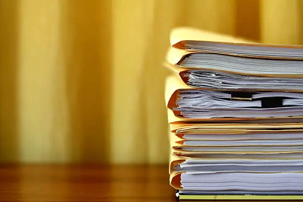 Manila file folders stacked on a desk.