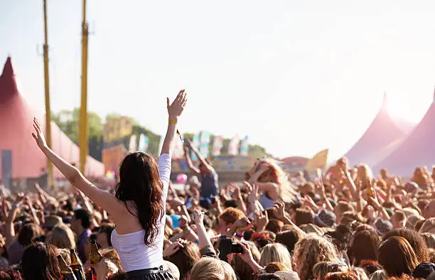 Photo of People with their arms in air at music festival