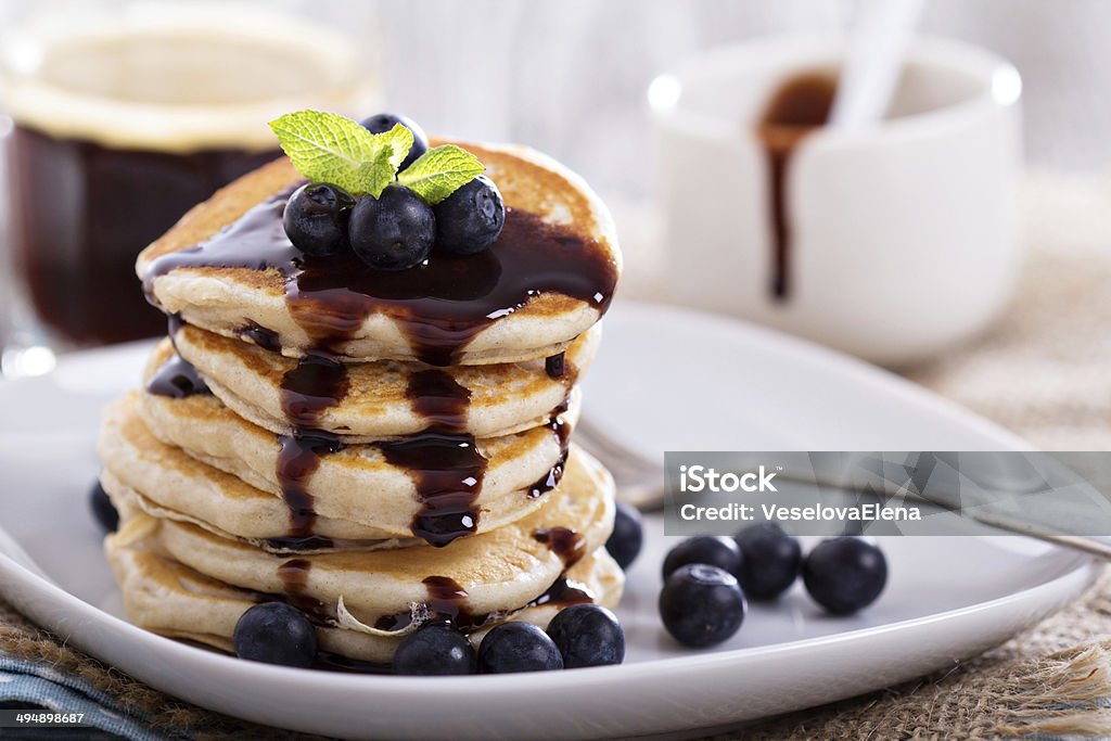 Eggless pancakes with blueberries and chocolate Eggless pancakes for breakfast with blueberries and chocolate sauce Berry Stock Photo