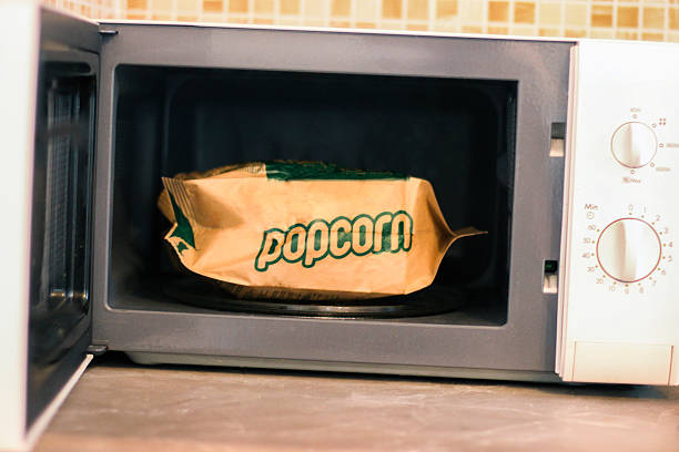 Preparing microwave popcorn Preparing popcorn in a microwave oven. inside microwave stock pictures, royalty-free photos & images