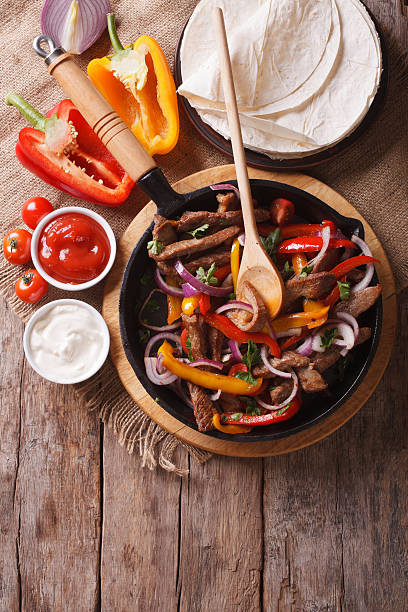 istock Mexican fajitas on a table, rustic style vertical top view 494919206