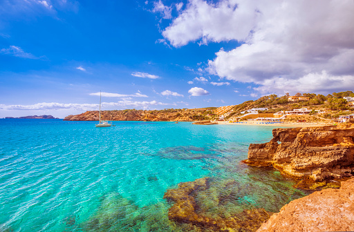 View on the beautiful beach and bay of Cala Tarida, famous for its clear, sandy, shallow and turquoise waters.