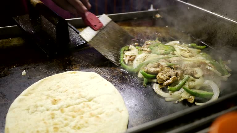 Man preparing gyros at an outdoors food kiosk in New York City