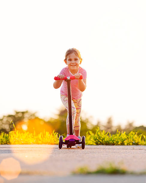 istock Little girl riding push scooter. 494933287