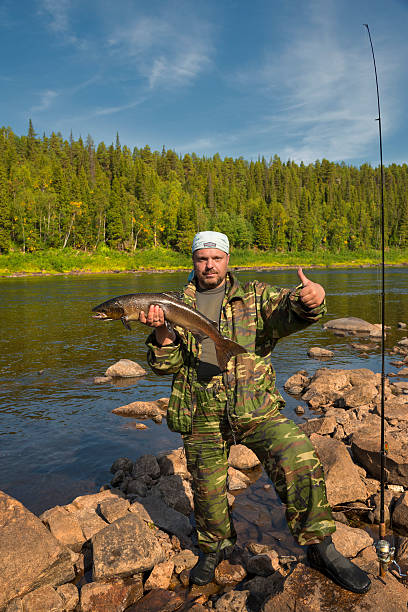 istock Fisherman holding a large fish salmon. 494933453
