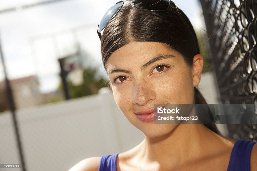 Casual Latin descent young woman. Sports court. Portrait. Close-up. Close up of pretty, Latin descent young woman outside in summer.  This fresh new face is pictured in front of a sports court. 20-29 Years Stock Photo