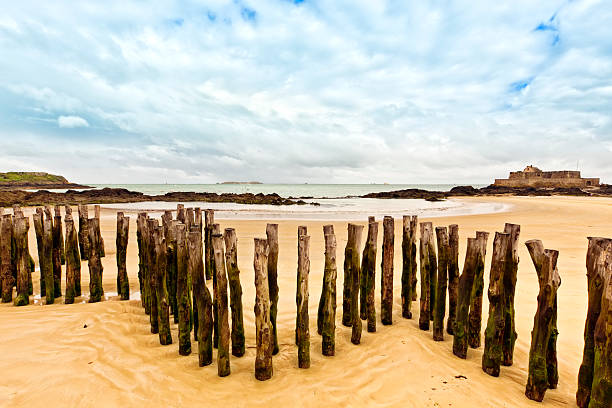Beach of Saint-Malo with wooden breakwaters and Fort National