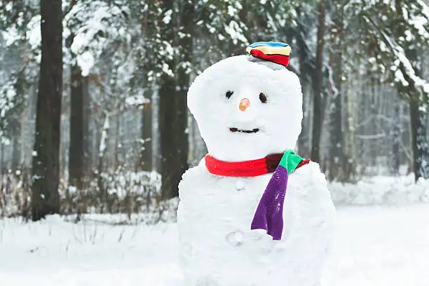 Festive winter three-ball dressed snowman with smiley face and carrot nose