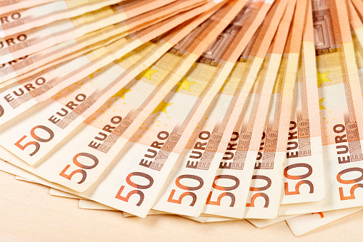 Close-up of bills of fifty euro on a desk.