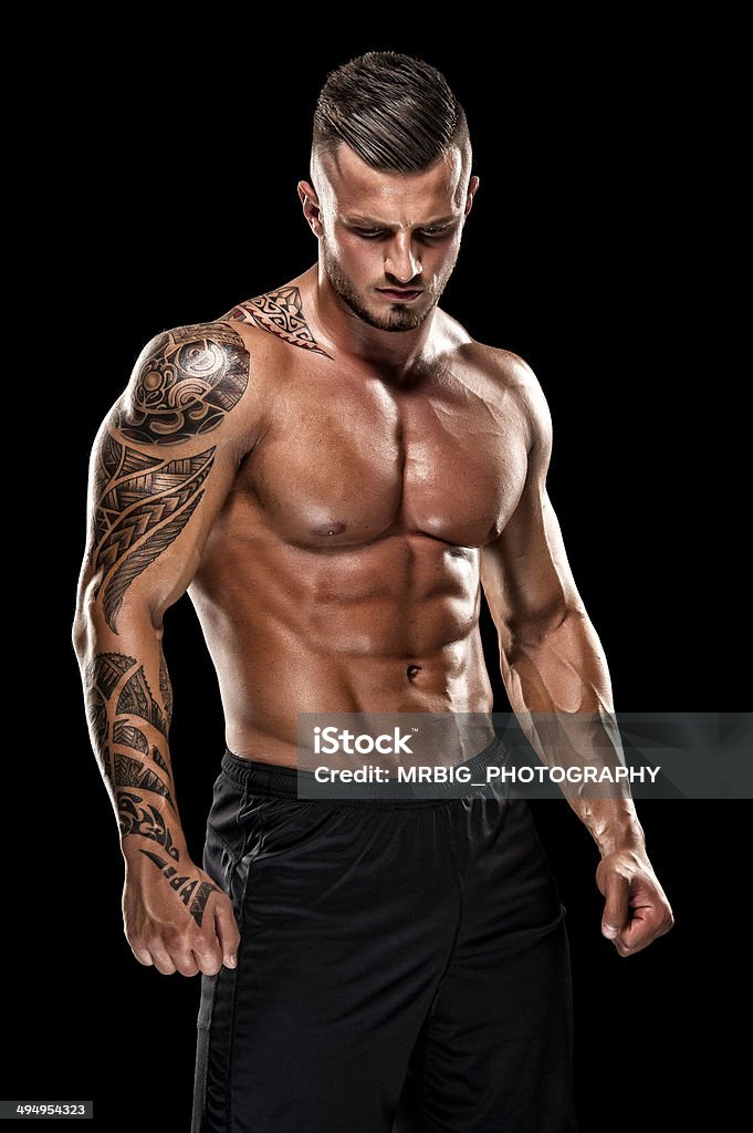 Handsome Muscular Men Portrait of a physically fit, muscular young man without a shirt. Tattoo Stock Photo