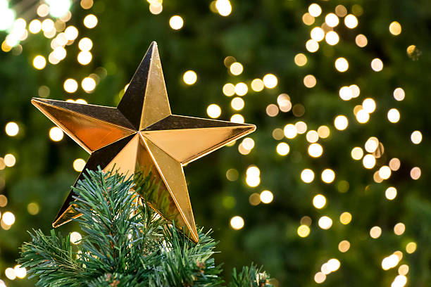 istock golden star on christmas tree and lights 494958336