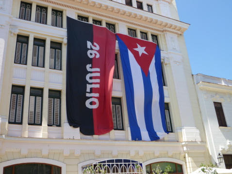 Large 26 July movement and Cuban flags ona faceade of a building in Havana, Cuba