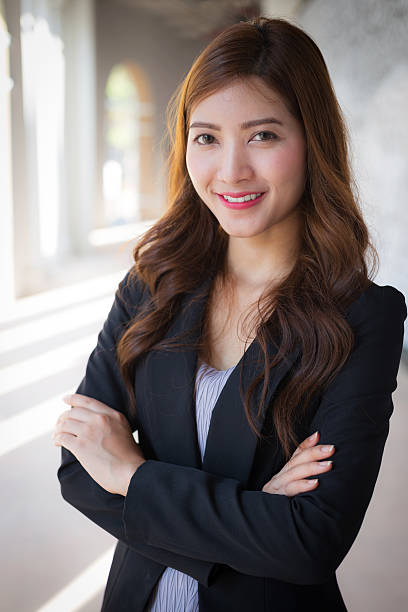 Businesswoman standing crossed arms with smiling face stock photo