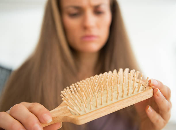 istock Concerned young woman looking on hair comb. Closeup 494961475