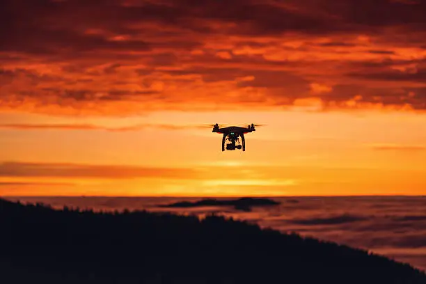 Personal drone flying through the air, sunrise shot