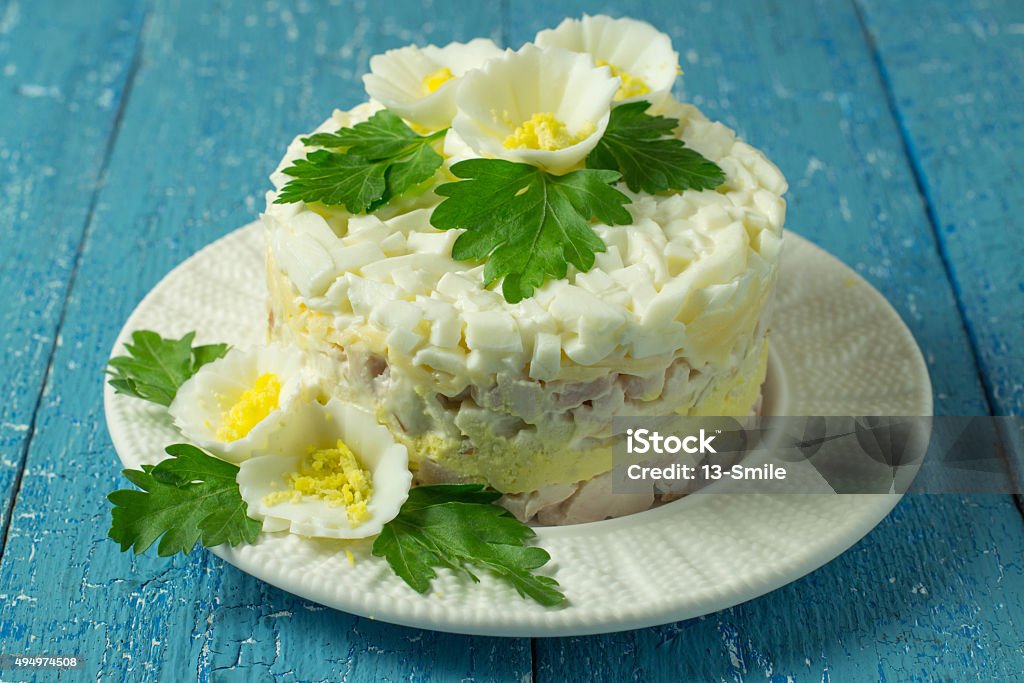 Festive salad Multilayer festive chicken salad with egg and cheese on a blue wooden background 2015 Stock Photo