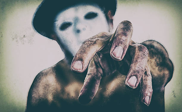 Retro Grubby Photo Spooky Horror Hand Reaching Retro, distressed photo treatment on a cropped image of a spooky, masked man reaching his grubby hand toward the camera. ominous photos stock pictures, royalty-free photos & images